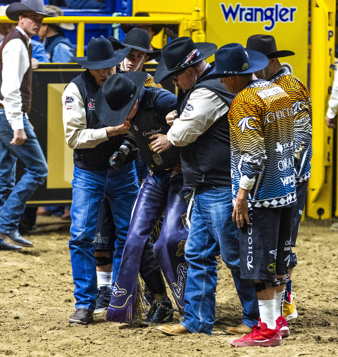 Ky Hamilton is assisted out of the arena after a failed ride on Cross Eyed Kelly in Bull Riding ...