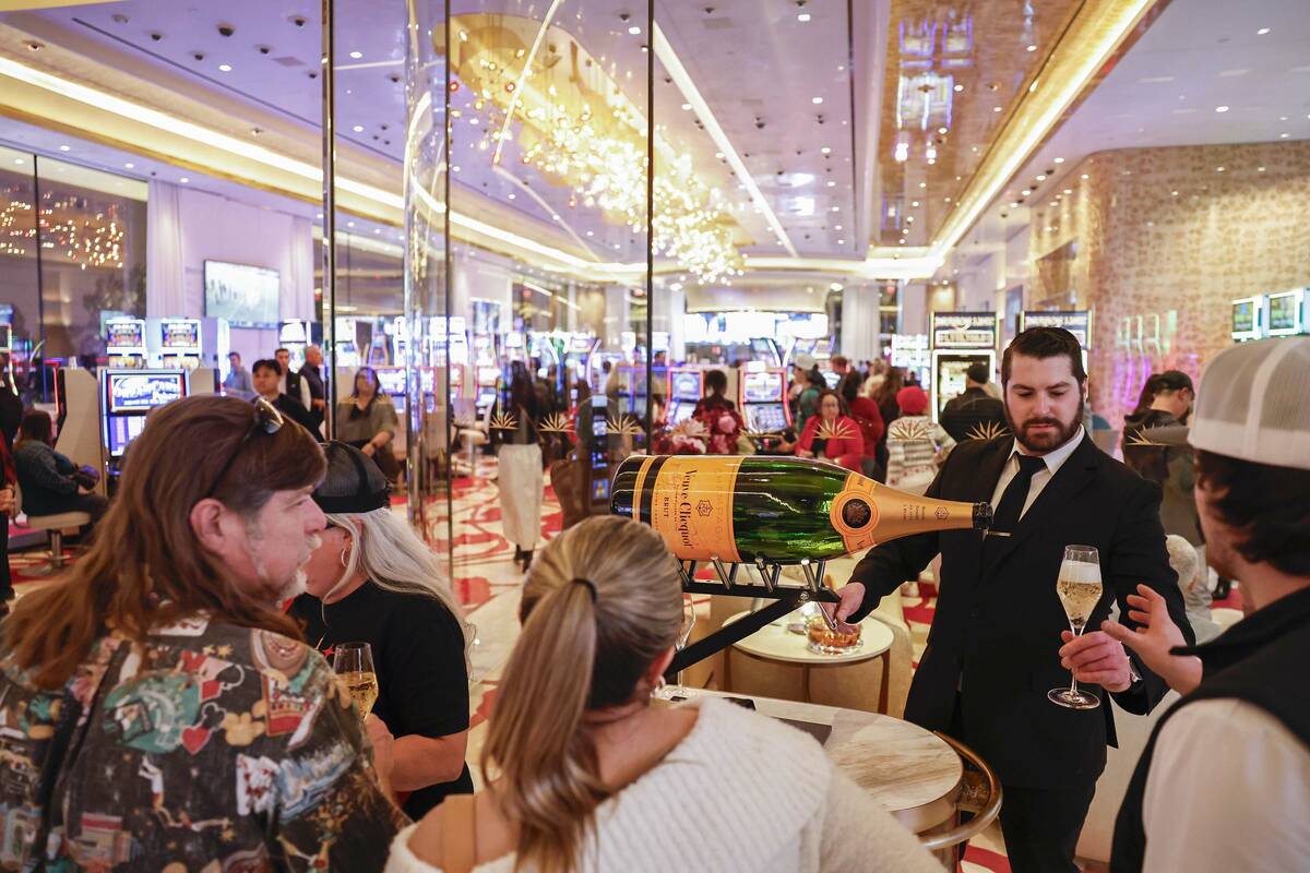 Logan Pankhurst, top/right, lead sommelier for Station Casinos, pours glasses of champagne for ...
