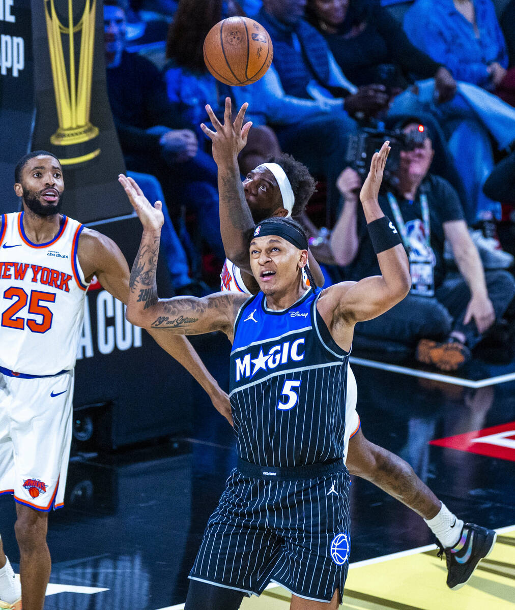 Orlando Magic forward Paolo Banchero (5) has New York Knicks center Mitchell Robinson (23) reac ...