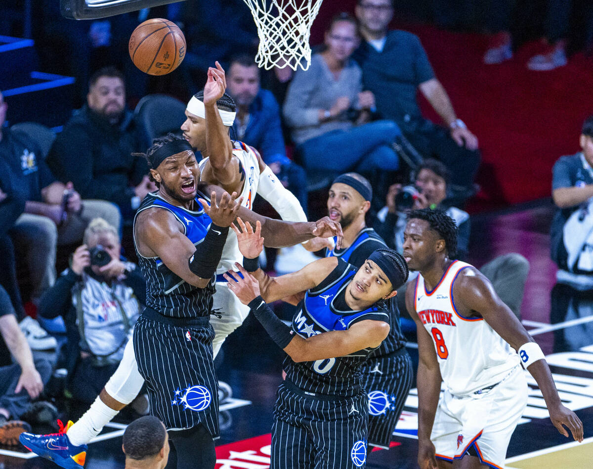 Orlando Magic center Wendell Carter Jr. (34) and guard Anthony Black (0) fight for a loose ball ...