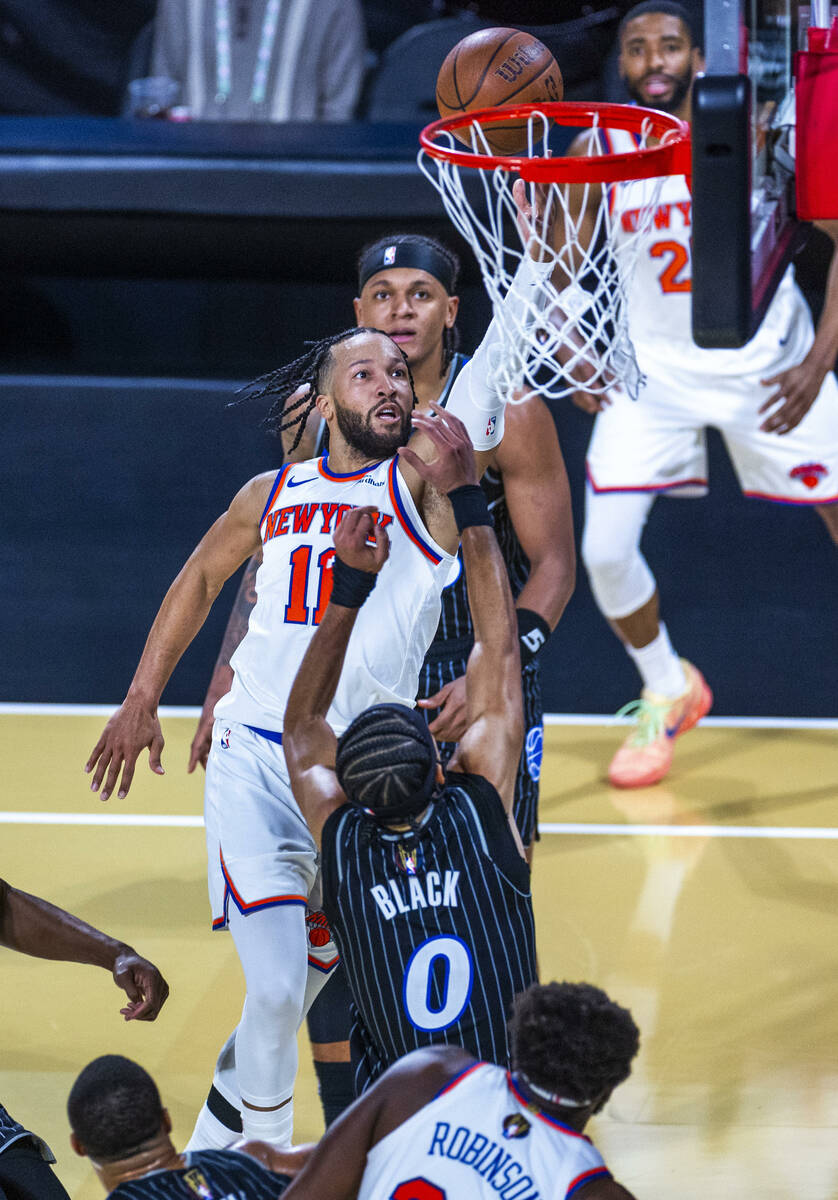New York Knicks guard Jalen Brunson (11) lays the ball in over Orlando Magic guard Anthony Blac ...