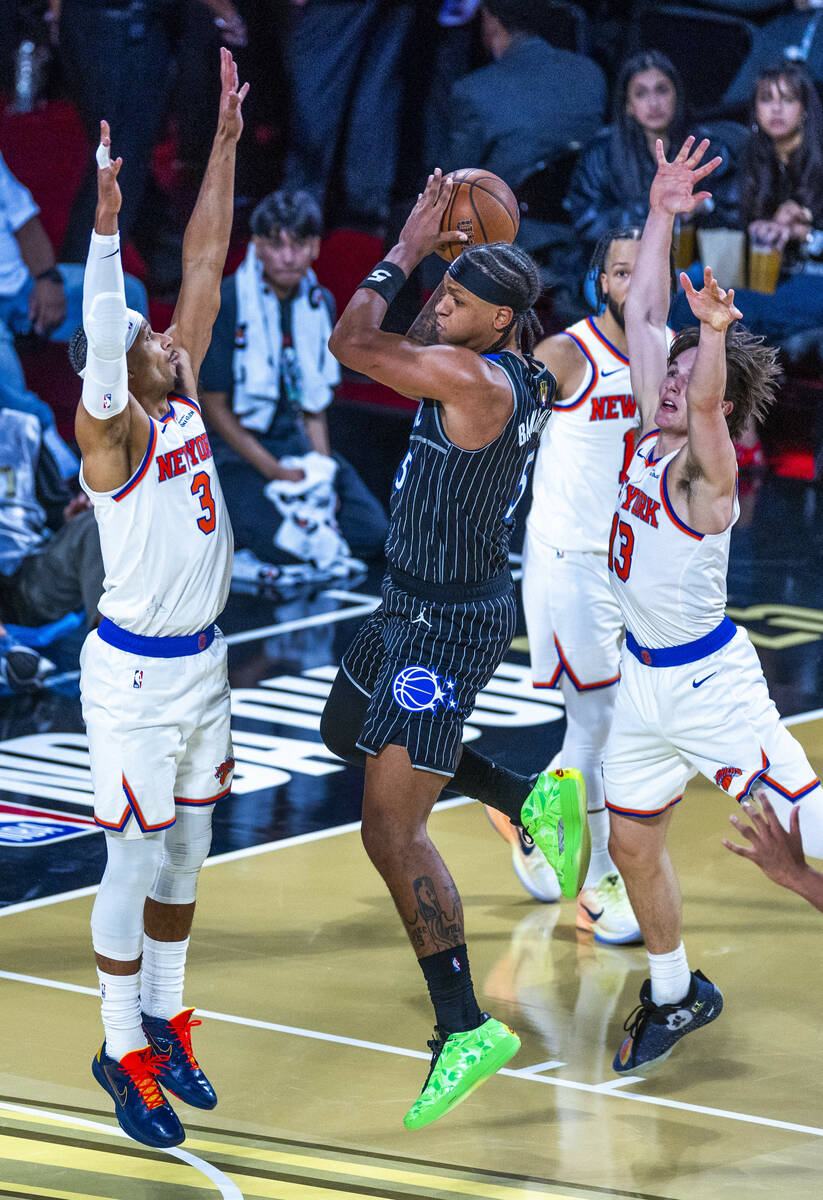 Orlando Magic forward Paolo Banchero (5) looks to shoot between New York Knicks guard Josh Hart ...