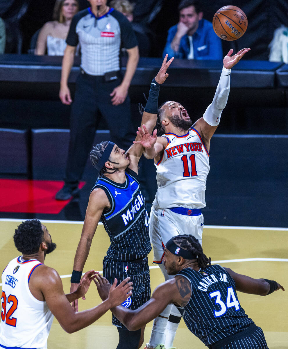 New York Knicks guard Jalen Brunson (11) battles to get a shot off over Orlando Magic guard Ant ...