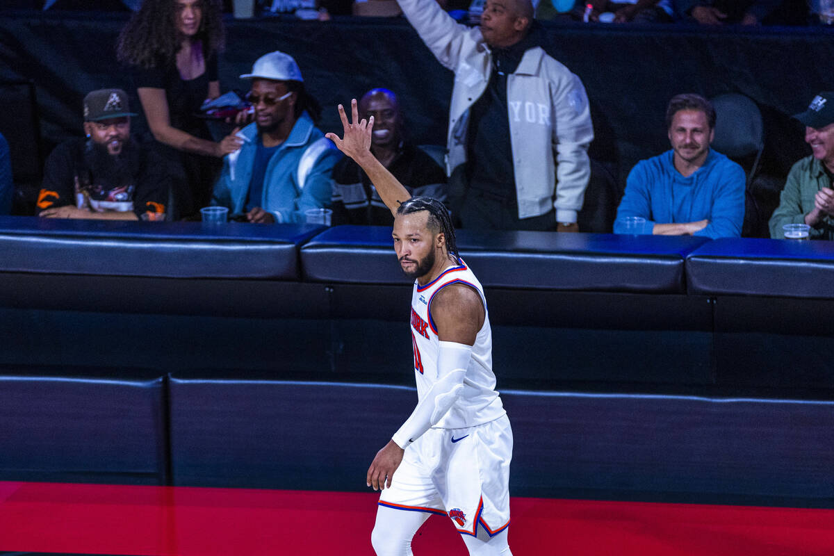 New York Knicks guard Jalen Brunson (11) signals another three-point basket against the New Yor ...