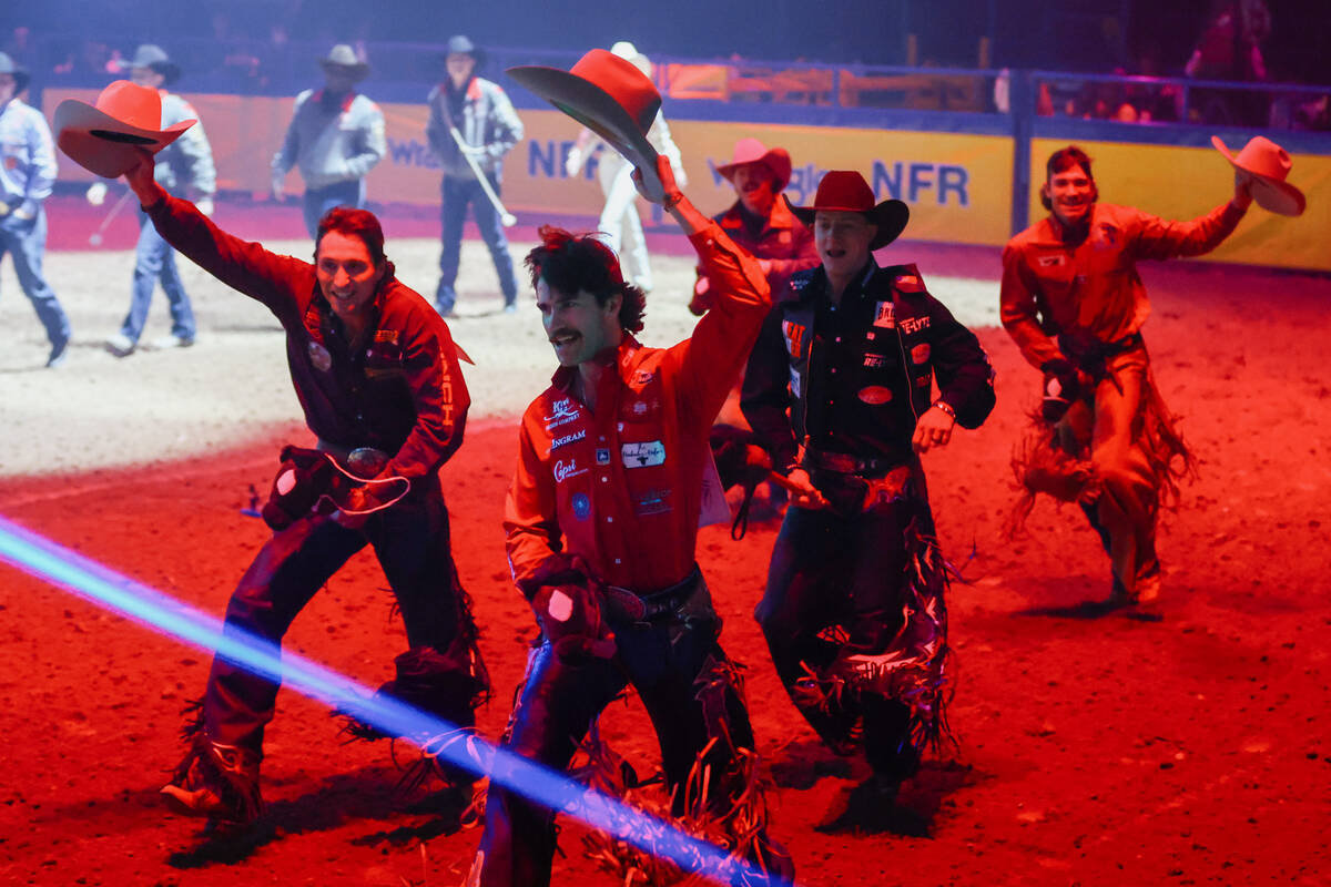 Bull riding contestants run out of the arena after introductions in the 10th go-round of the Na ...