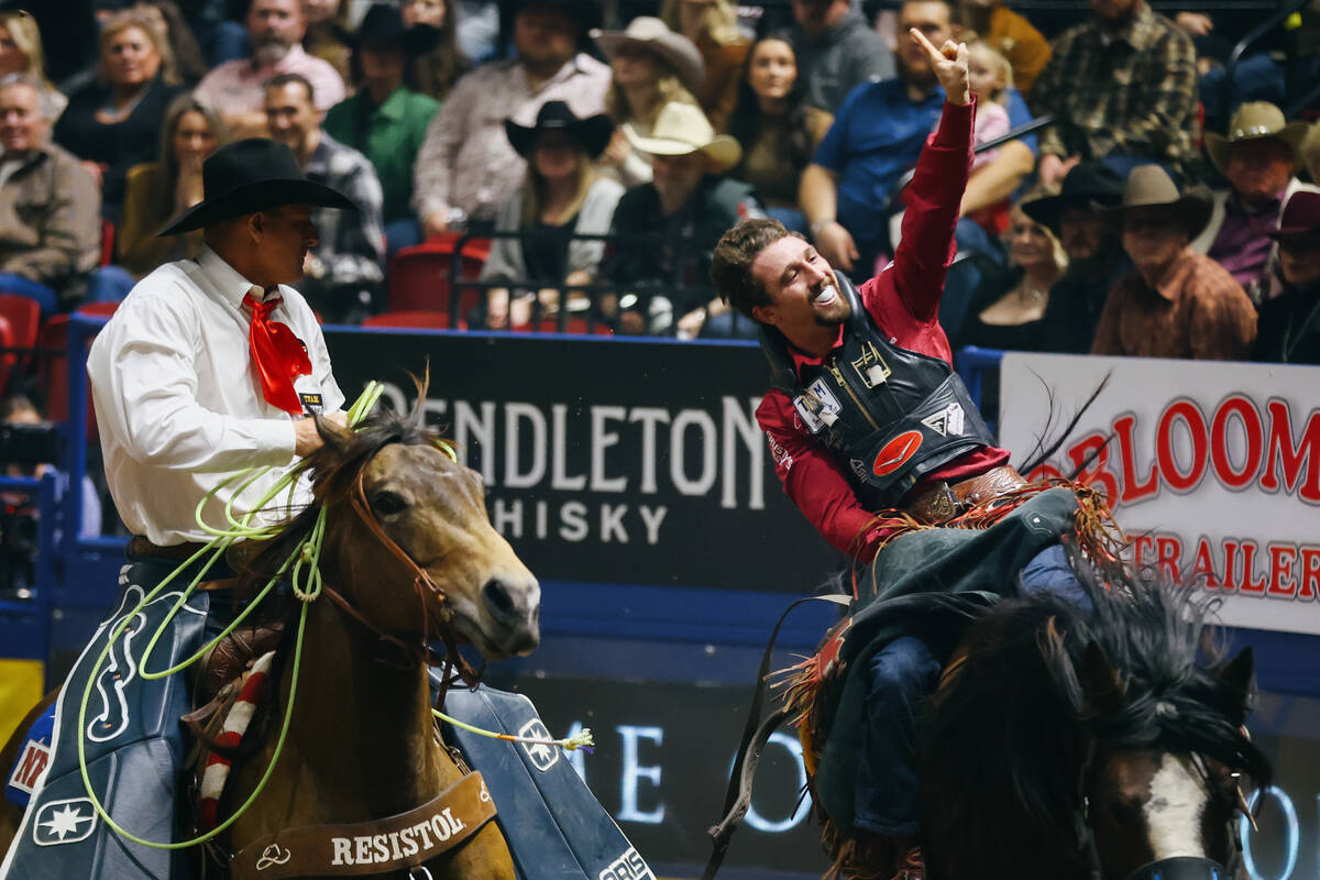 Garrett Shadbolt celebrates as he rides Fringe Jacket for the bareback riding event in the 10th ...