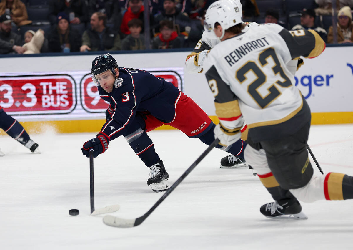 Columbus Blue Jackets center Charlie Coyle (3) reaches for the puck as Vegas Golden Knights lef ...