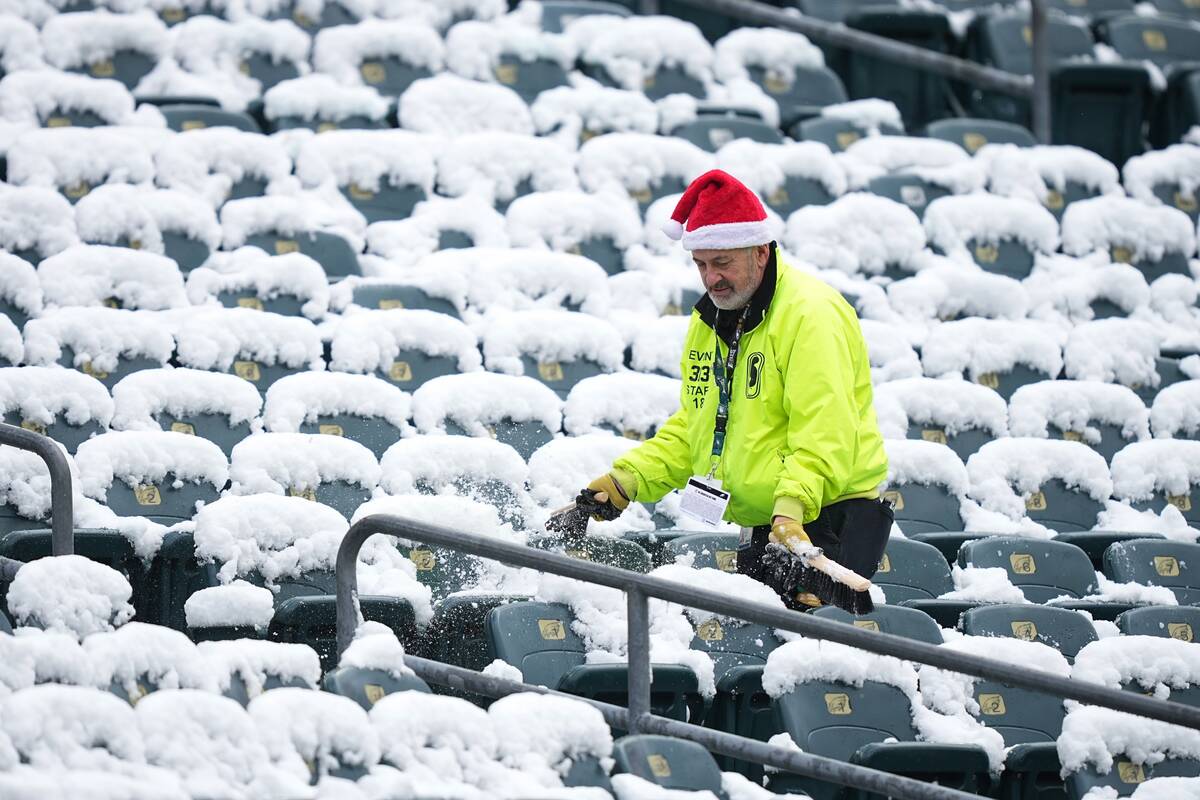 Snow is cleared from seats before an NFL football game between the Philadelphia Eagles and the ...