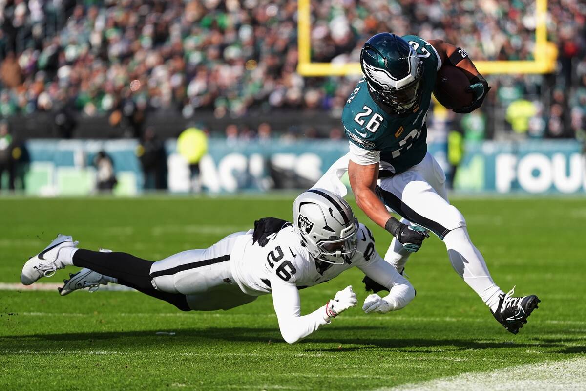 Philadelphia Eagles running back Saquon Barkley (26) runs with the ball as Las Vegas Raiders co ...