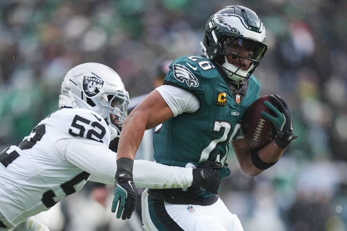 Philadelphia Eagles running back Saquon Barkley (26) is brought down by Las Vegas Raiders outsi ...