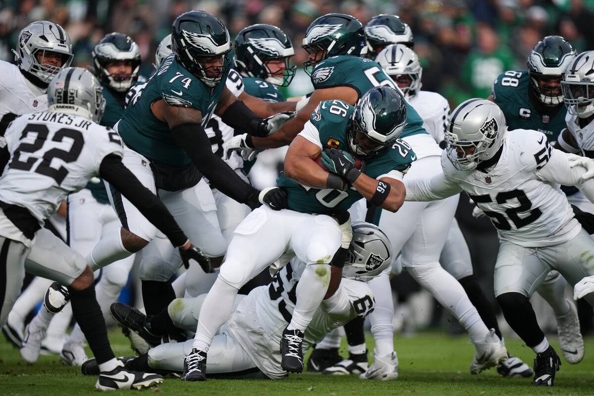 Philadelphia Eagles running back Saquon Barkley (26) is brought down by Las Vegas Raiders outsi ...