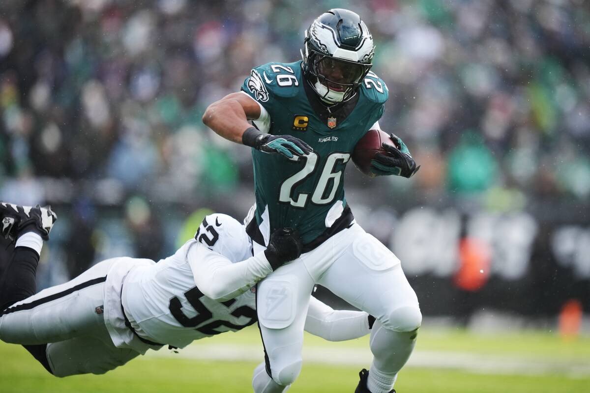 Philadelphia Eagles running back Saquon Barkley (26) is brought down by Las Vegas Raiders outsi ...