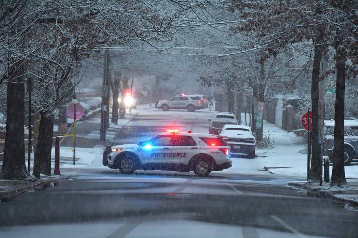 Police vehicles rest in intersections in a neighborhood near Brown University, Sunday, Dec. 14, ...
