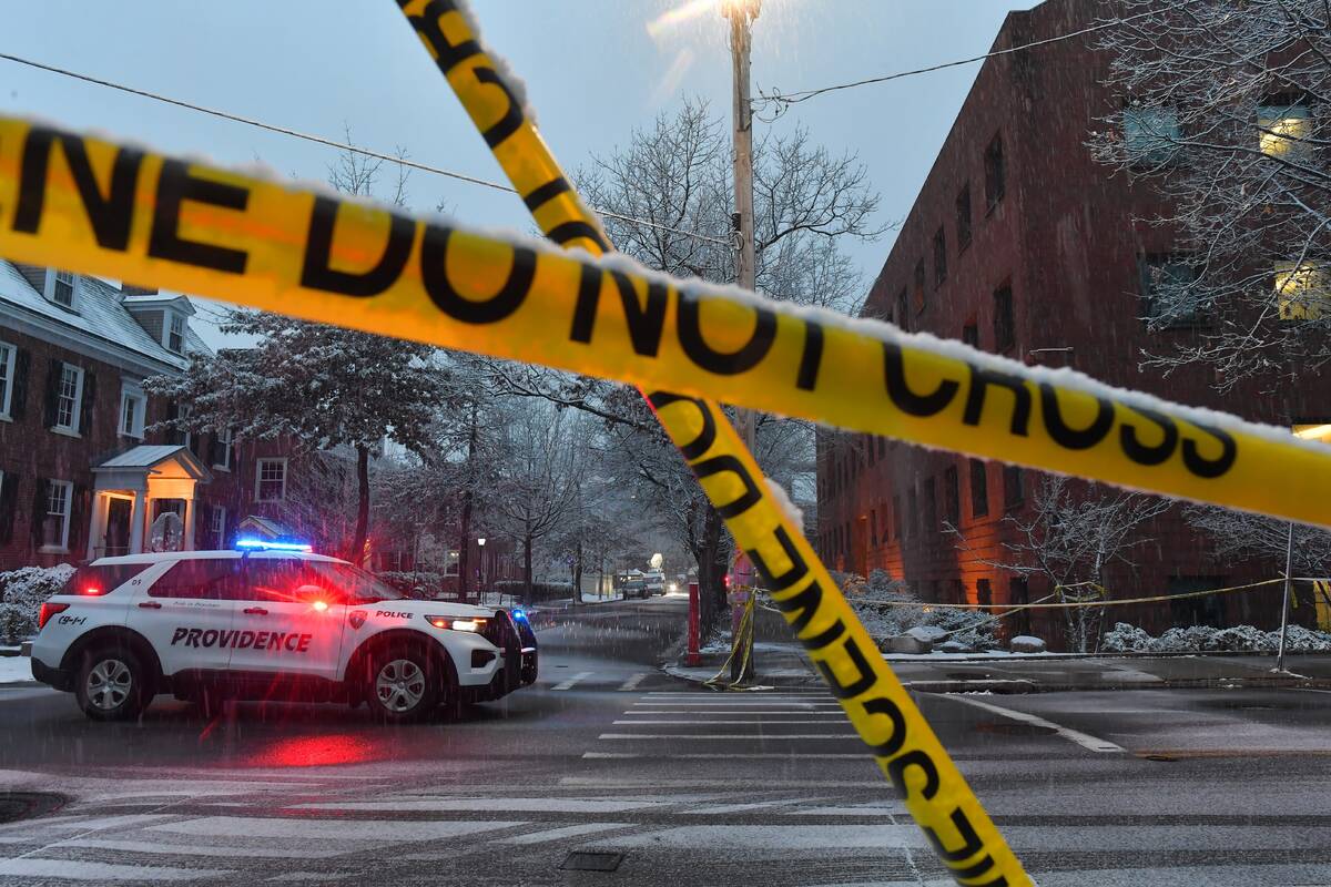 A police vehicle rests at an intersection near crime scene tape at Brown University, Sunday, De ...