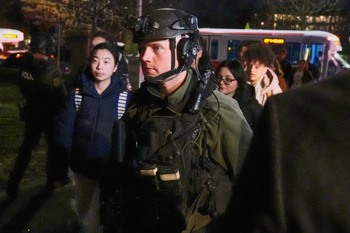 Students are escorted by law enforcement officers to a building at Brown University after a sho ...