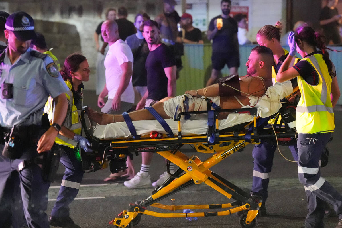 Emergency workers transport a person on a stretcher after a reported shooting at Bondi Beach in ...