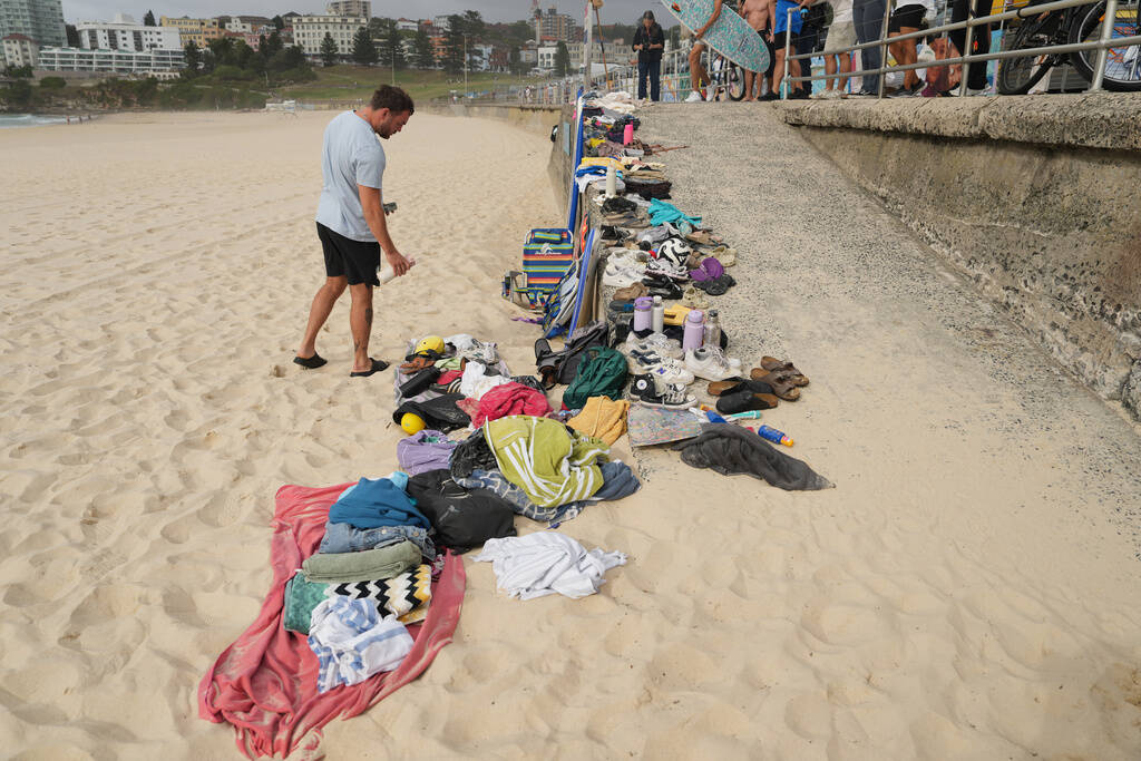 A man looks at belongings stacked up following a shooting the day prior at Sydney's Bondi ...