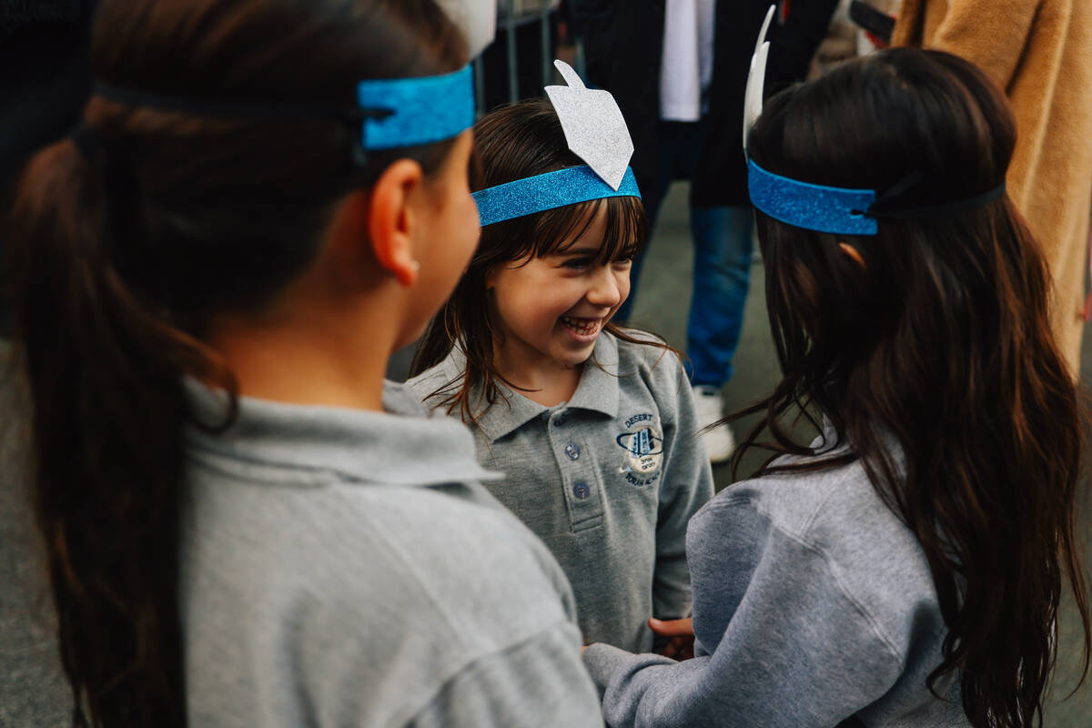 Children play with their headbands during the Fremont Street Experience menorah lighting Sunday ...