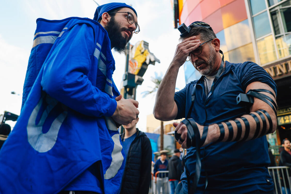 A participant prays as the tefillin is wrapped around him during the Fremont Street Experience ...