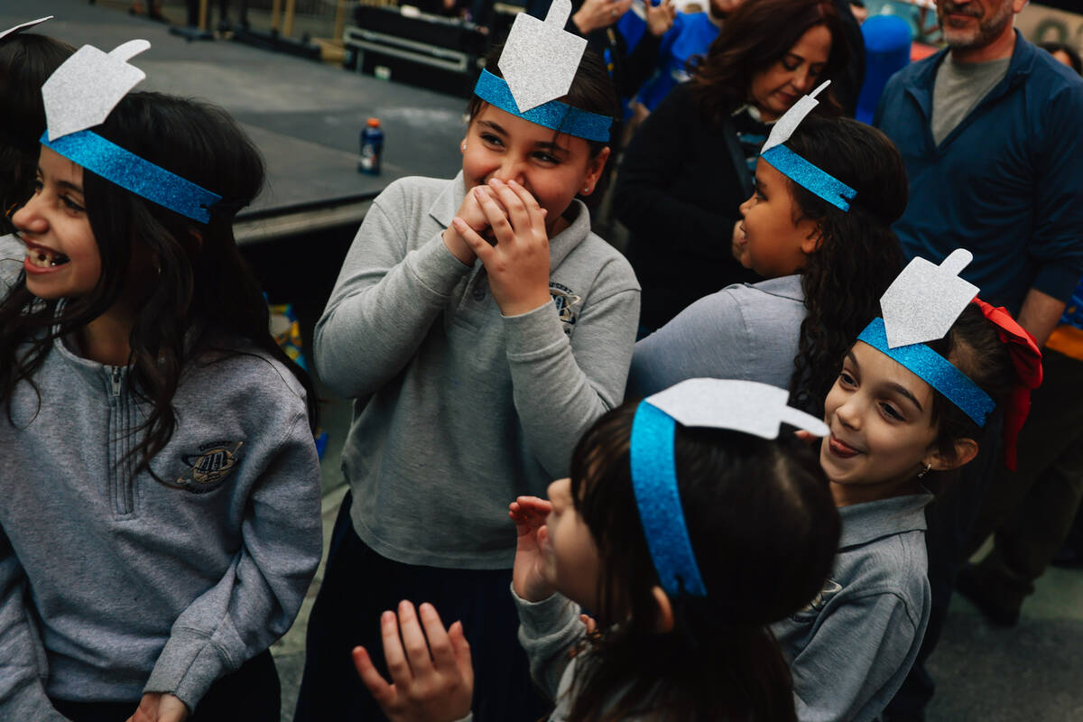 Children giggle together during the Fremont Street Experience menorah lighting Sunday, Dec. 14, ...