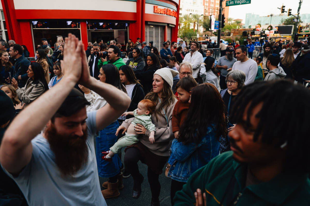 People listen to music during the Fremont Street Experience menorah lighting Sunday, Dec. 14, 2 ...