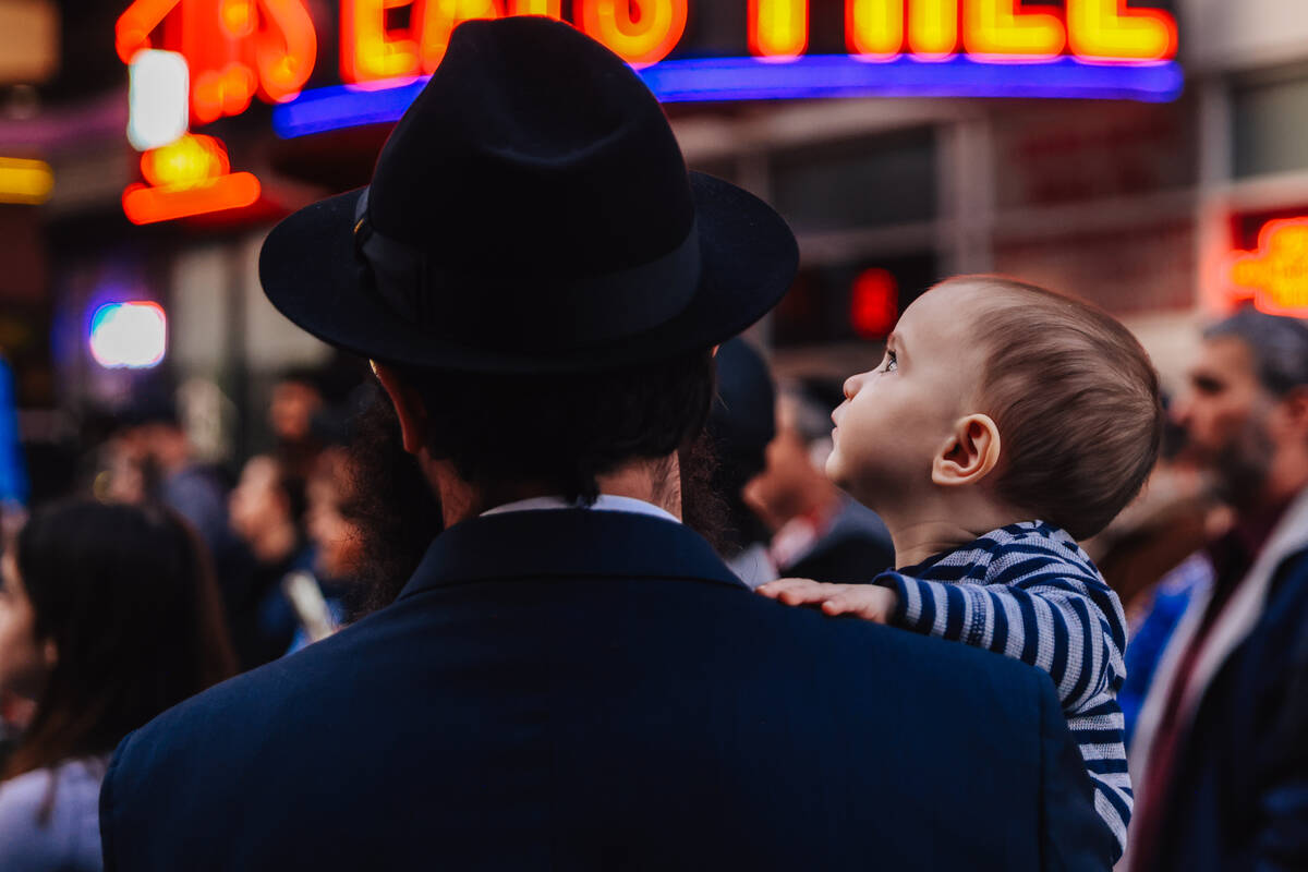 A baby watches entertainment during the Fremont Street Experience menorah lighting Sunday, Dec. ...
