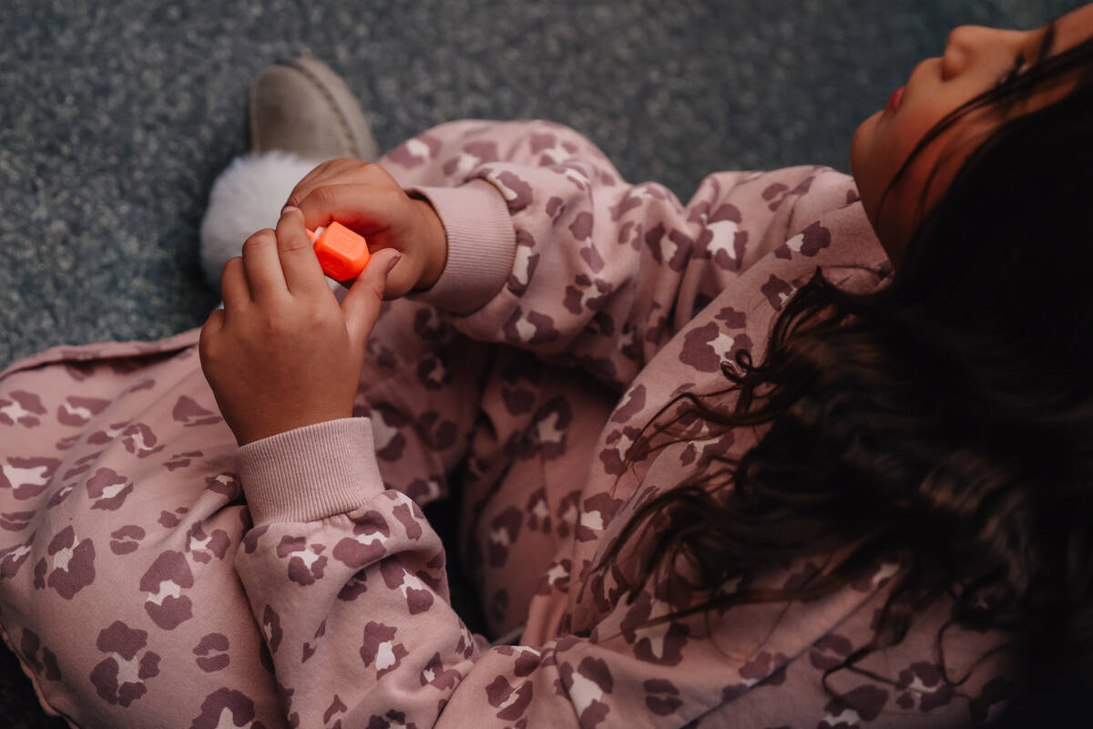 A child plays with a dreidel during the Fremont Street Experience menorah lighting Sunday, Dec. ...