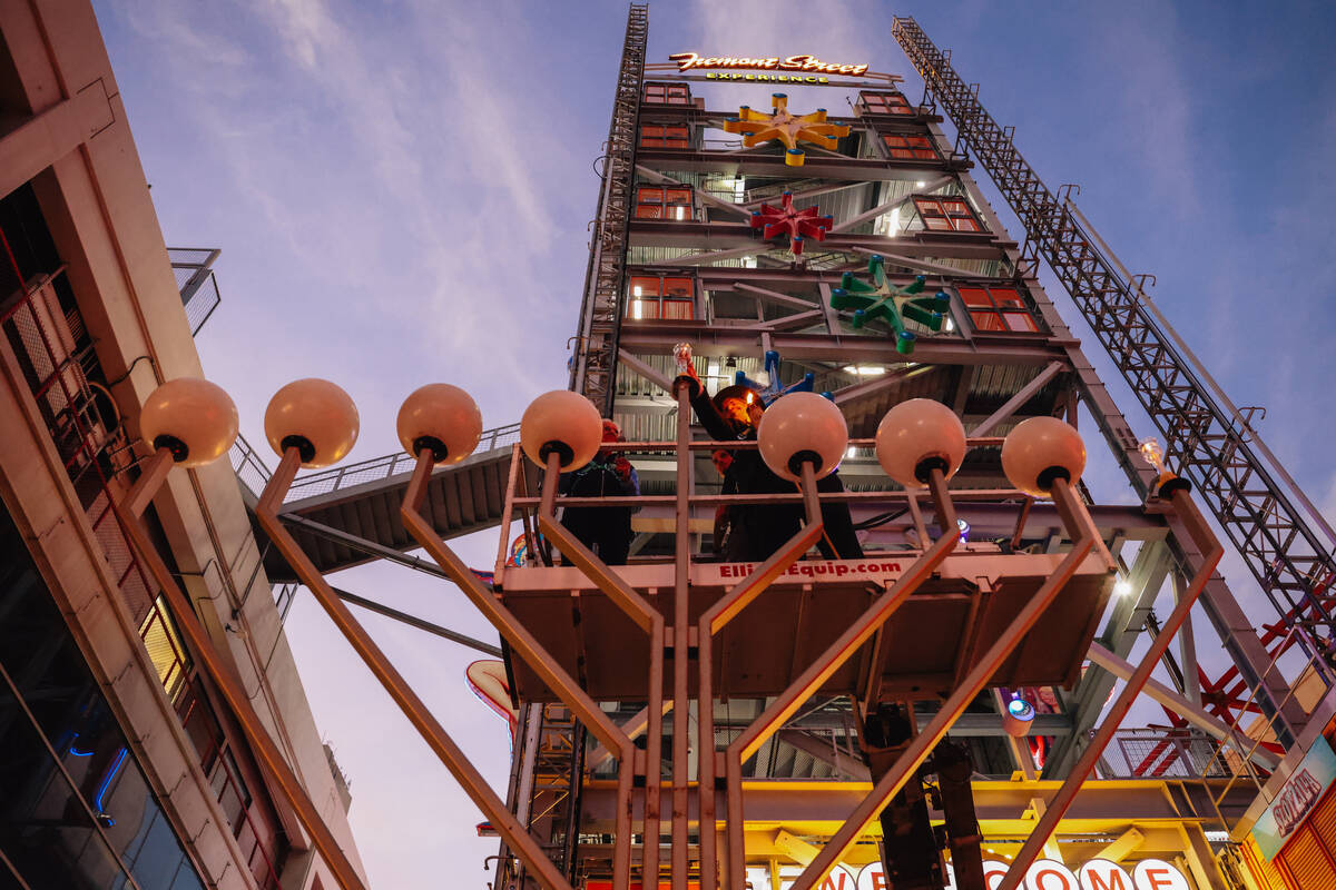 Rabbi Shea Harlig lights the menorah during the Fremont Street Experience menorah lighting Sund ...