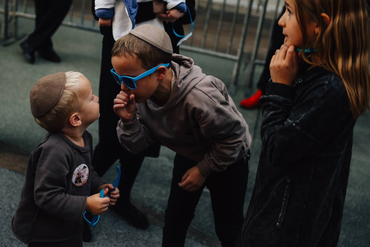 Children play during the Fremont Street Experience menorah lighting Sunday, Dec. 14, 2025, in L ...