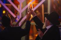 Commissioner Michael Naft, left, and Rabbi Shea Harlig light a menorah during an event for the ...