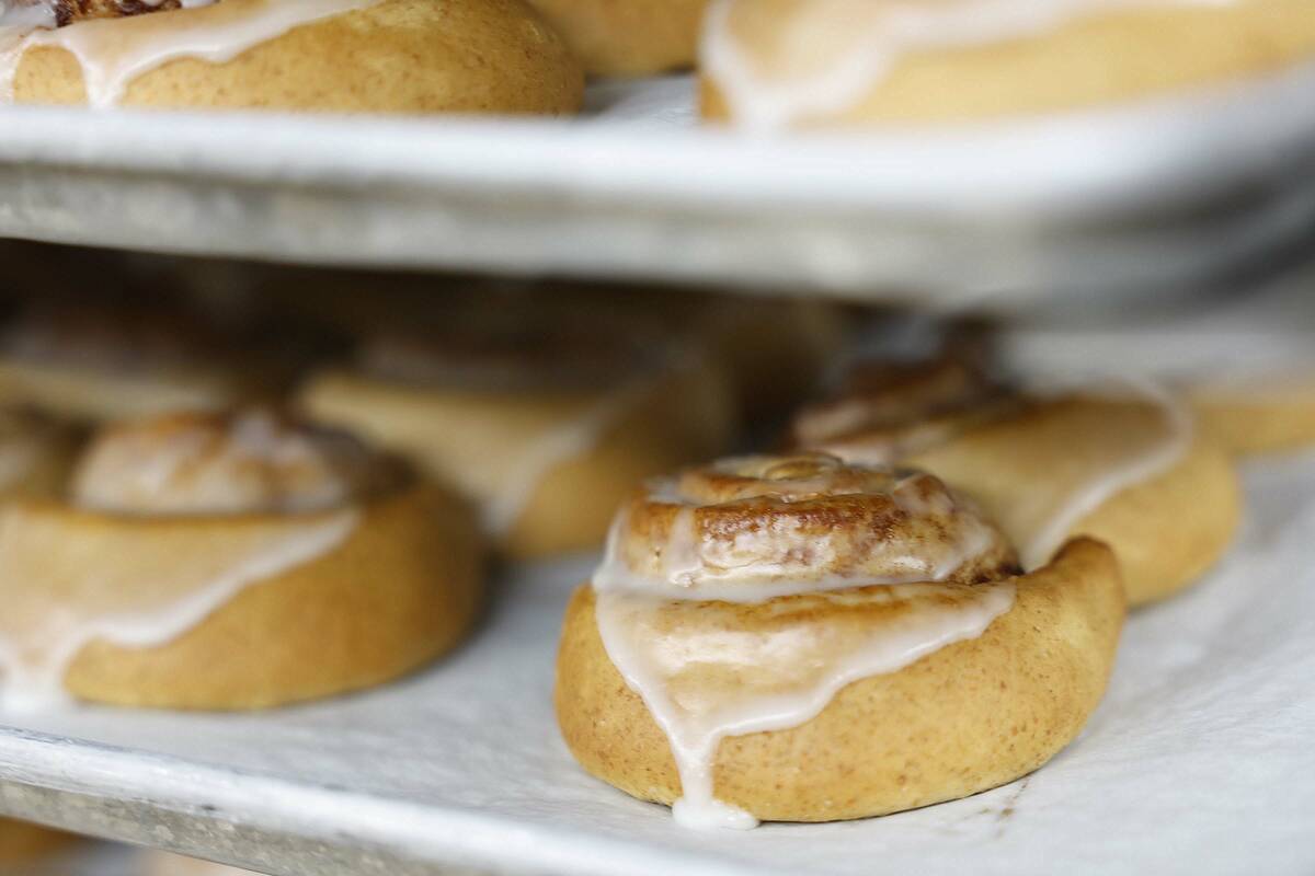 Large trays of honey buns cool outside of a walk-in oven at CCSD’s Central Kitchen Thurs ...