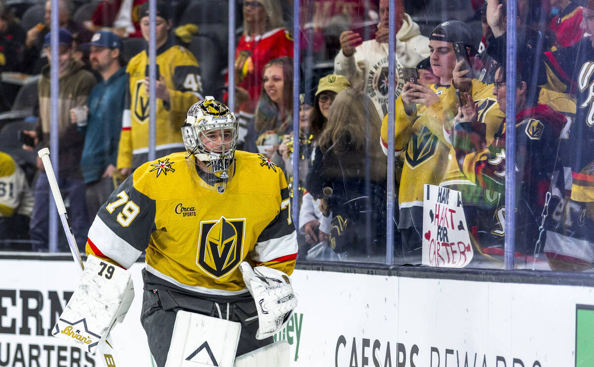 Golden Knights goaltender Carter Hart (79) skates past fans with welcoming signs during the war ...
