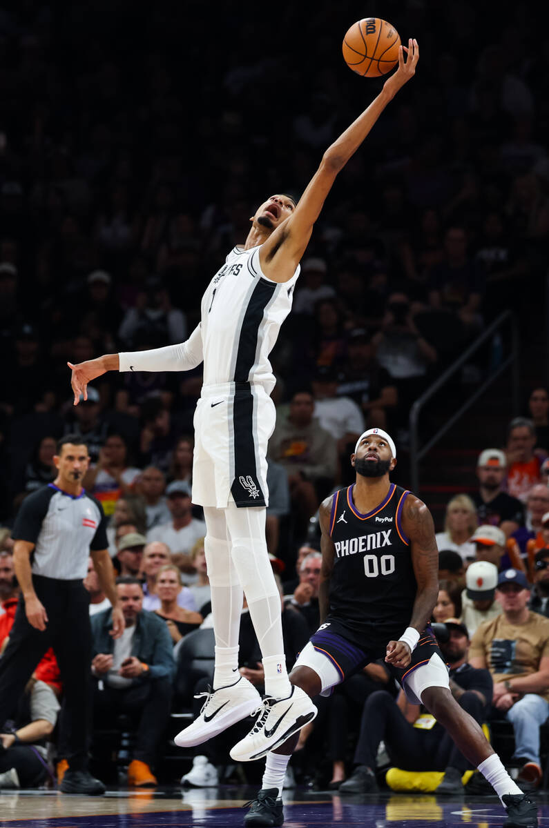 San Antonio Spurs forward Victor Wembanyama (1) corrals a loose ball as Phoenix Suns forward Ro ...