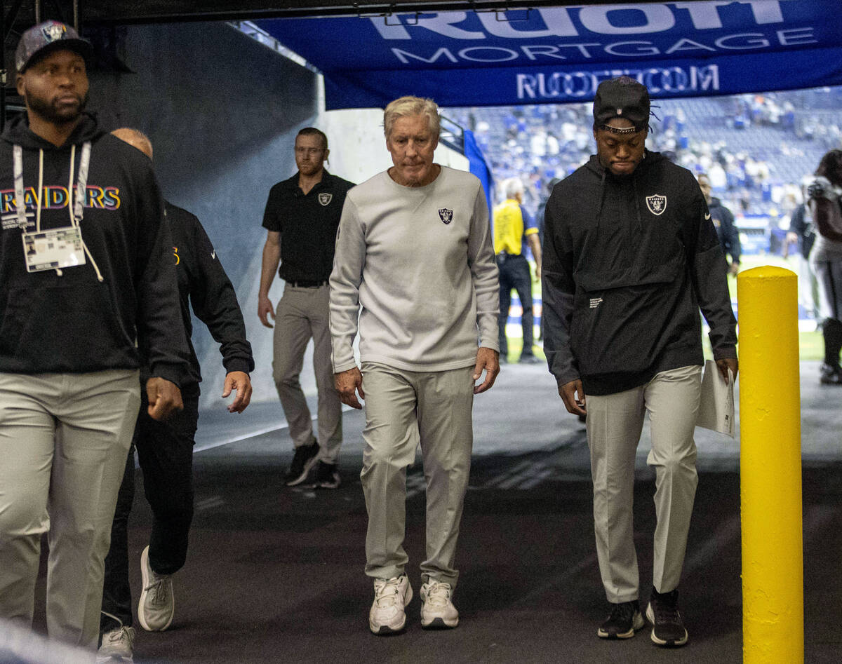 Raiders head coach Pete Carroll, center, returns to the locker following the team’s 40-6 ...