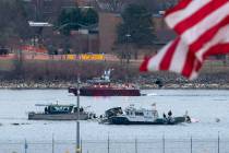 A diving team and police boat is seen near a wreckage site in the Potomac River, from Ronald Re ...