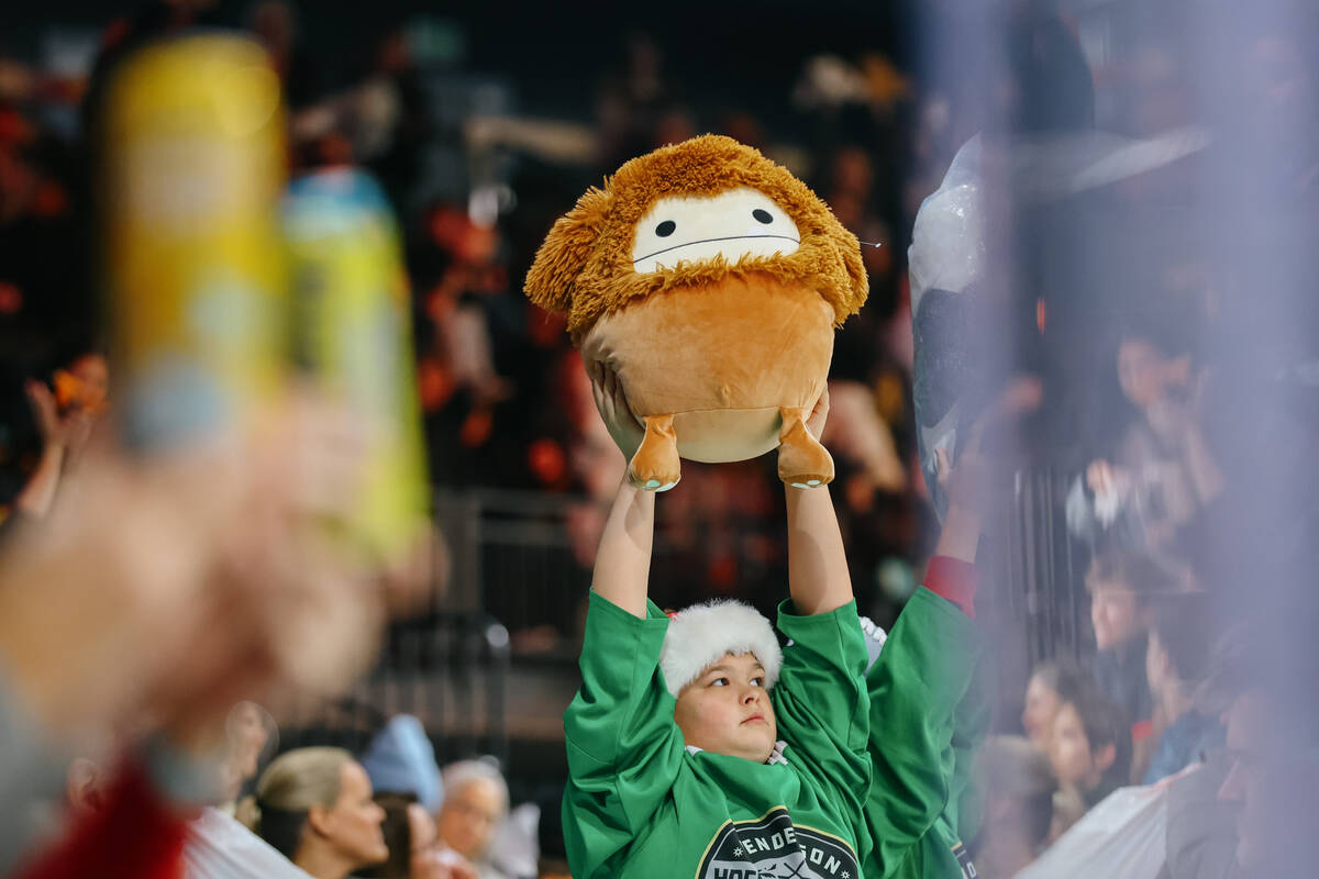 Fans hold up their toys, to be thrown over the barrier for Lucky Launch during a game between t ...