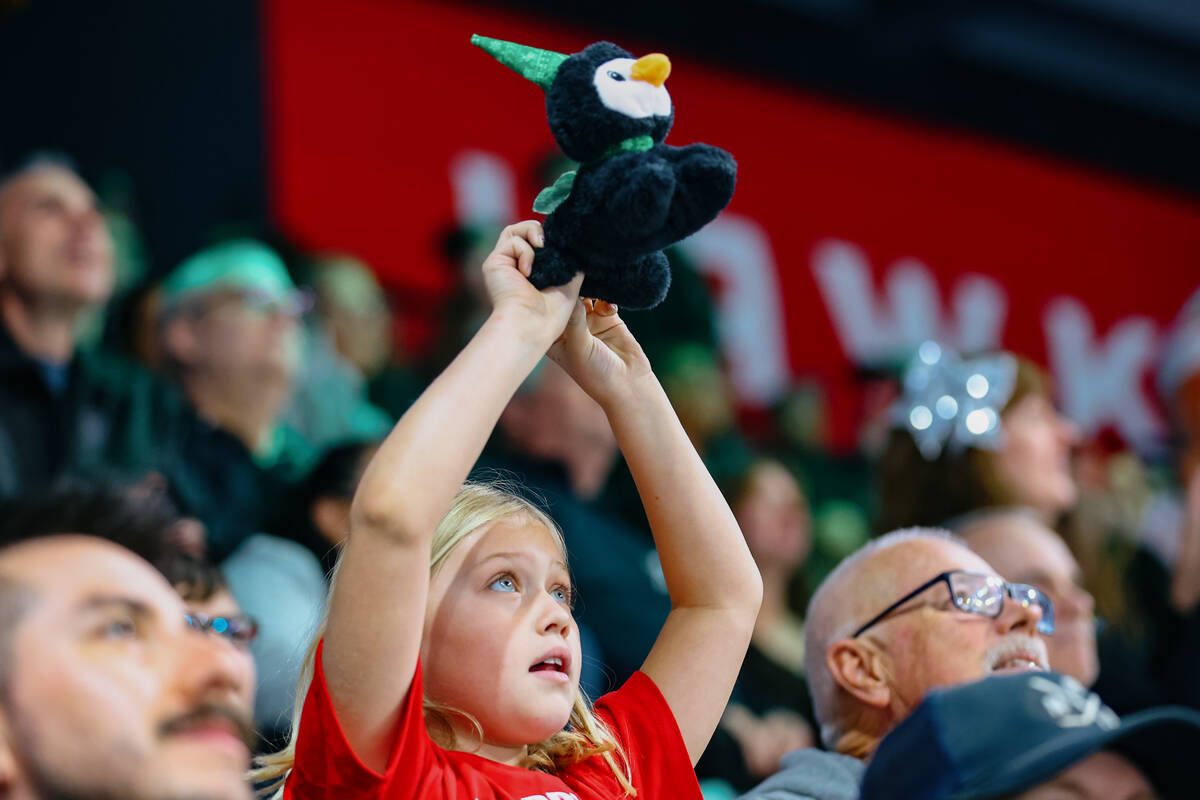 Fans hold up their toys, to be thrown over the barrier for Lucky Launch during a game between t ...