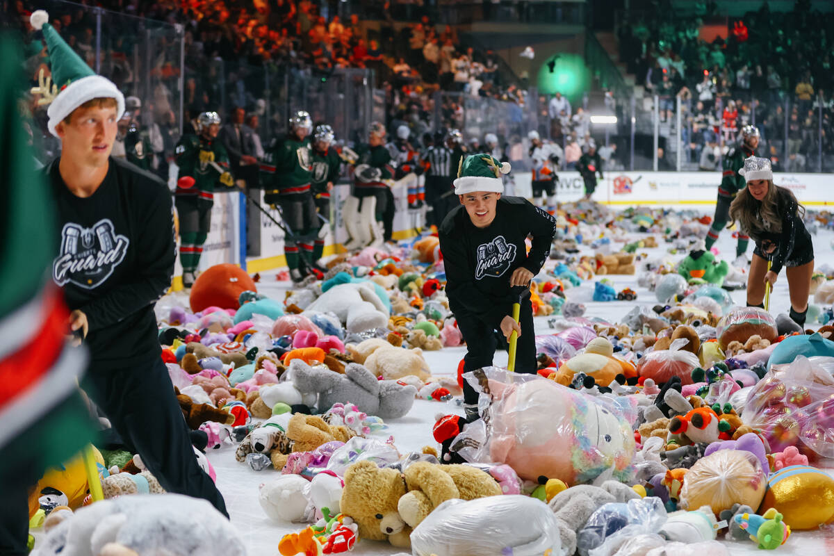 The Knights Guard starts clearing piles of toys from the rink after Lucky Launch during a game ...