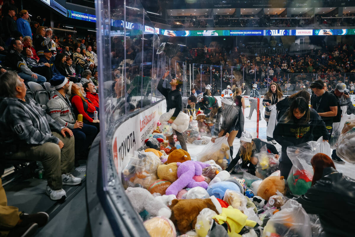 The Knights Guard starts clearing piles of toys from the rink after Lucky Launch during a game ...