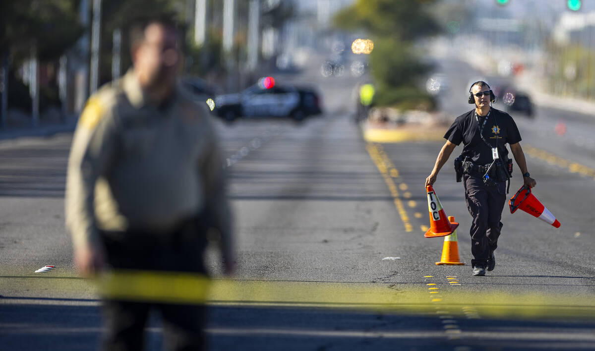 A Metropolitan Police Department negotiator puts cones on evidence as LVMPD and North Las Vegas ...