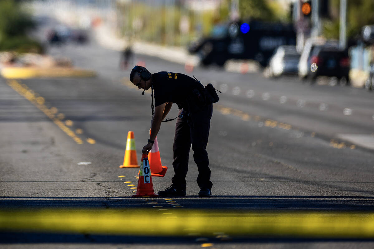 A Metropolitan Police Department negotiator puts cones on evidence as LVMPD and North Las Vegas ...