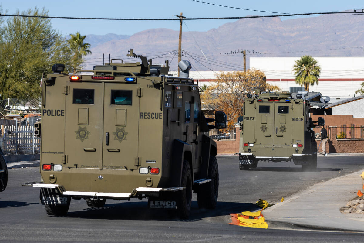 SWAT vehicles drive up North West Avenue as Metropolitan Police Department officers along with ...