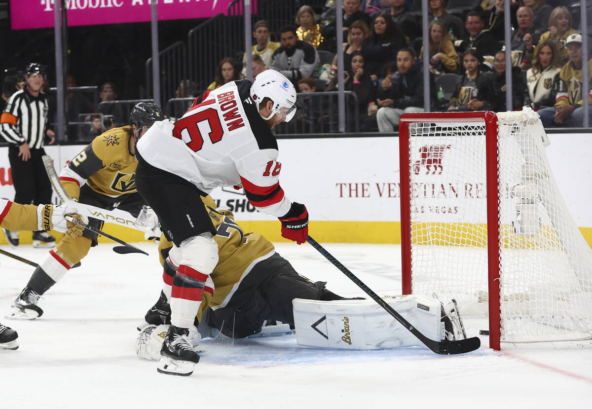 New Jersey Devils right wing Connor Brown (16) gets the puck into the net around Golden Knights ...