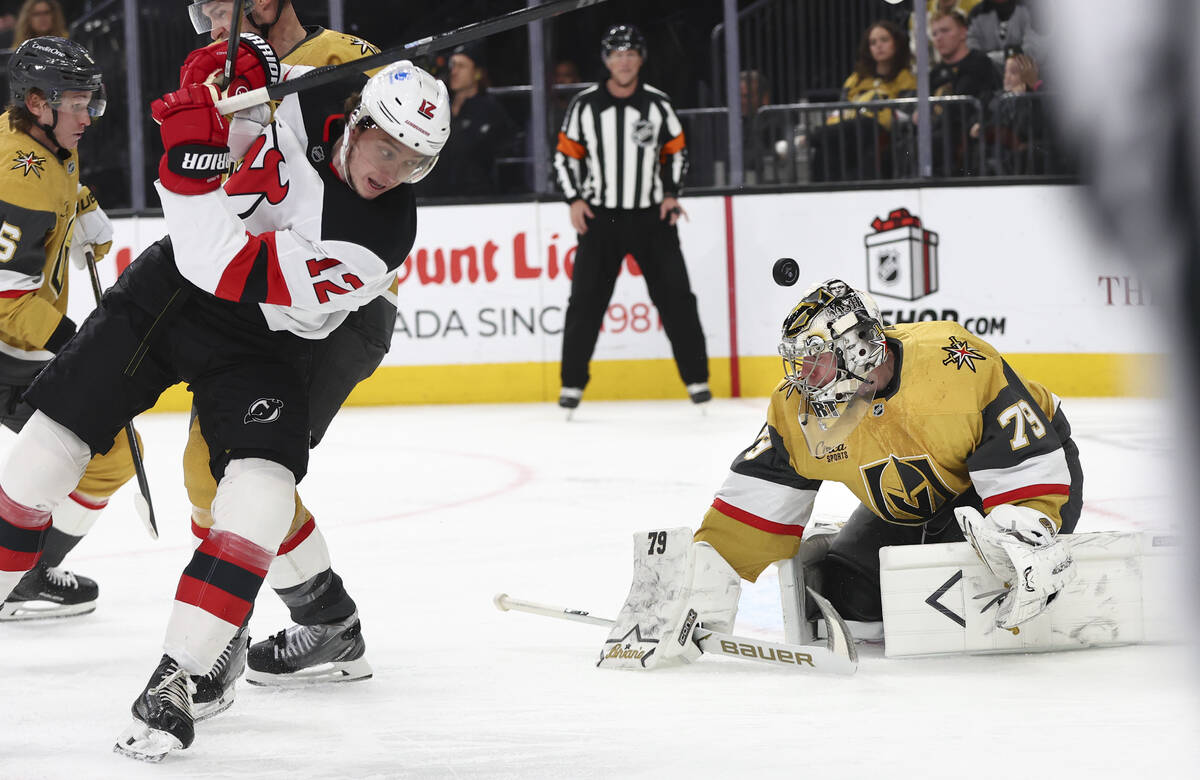 The puck bounces over Golden Knights goaltender Carter Hart (79) as New Jersey Devils center Co ...