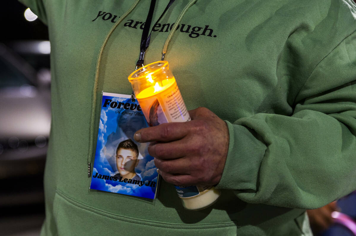 Mom Renee Riley holds a lit candle during a candlelight vigil for her son James Leamy Jr., in t ...