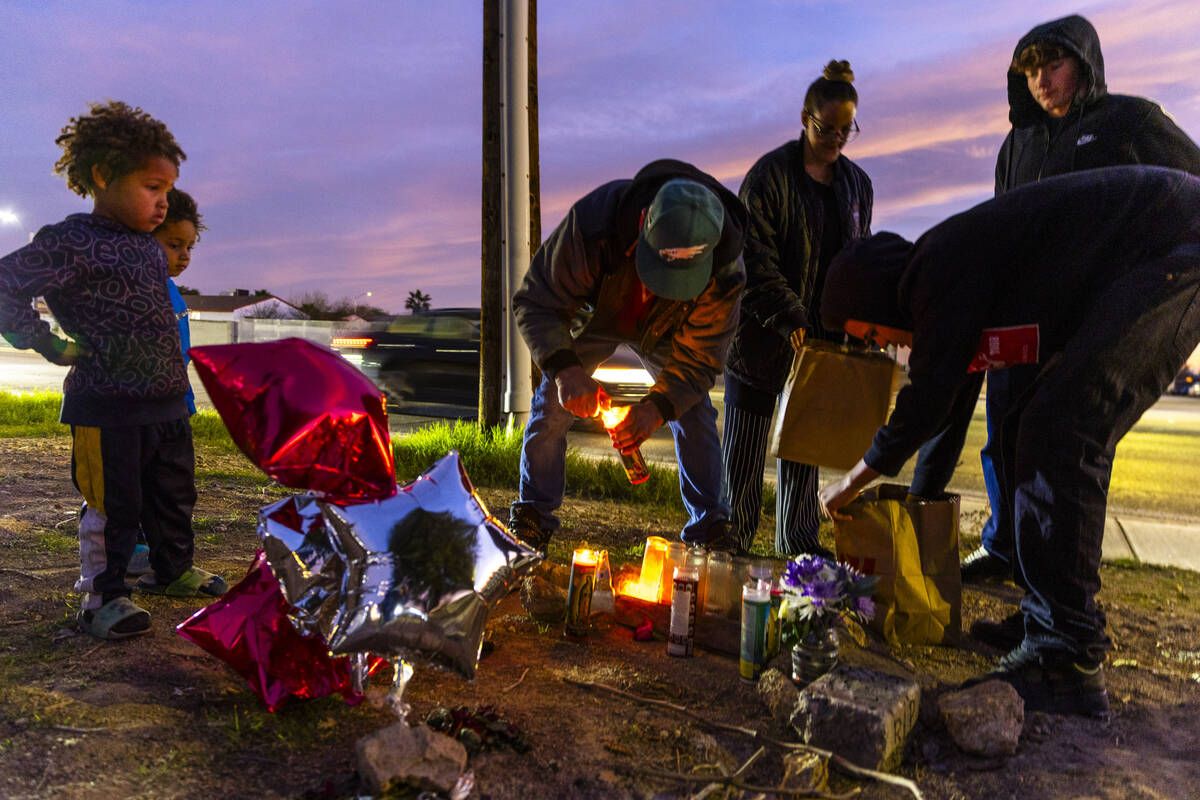 Family and friends light candles in remembrance of James Leamy Jr., during a vigil for him near ...