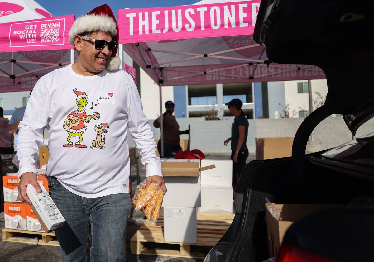 Volunteer Hector Navarro distributes food at The Just One Project Thursday, Dec. 18, 2025 in La ...
