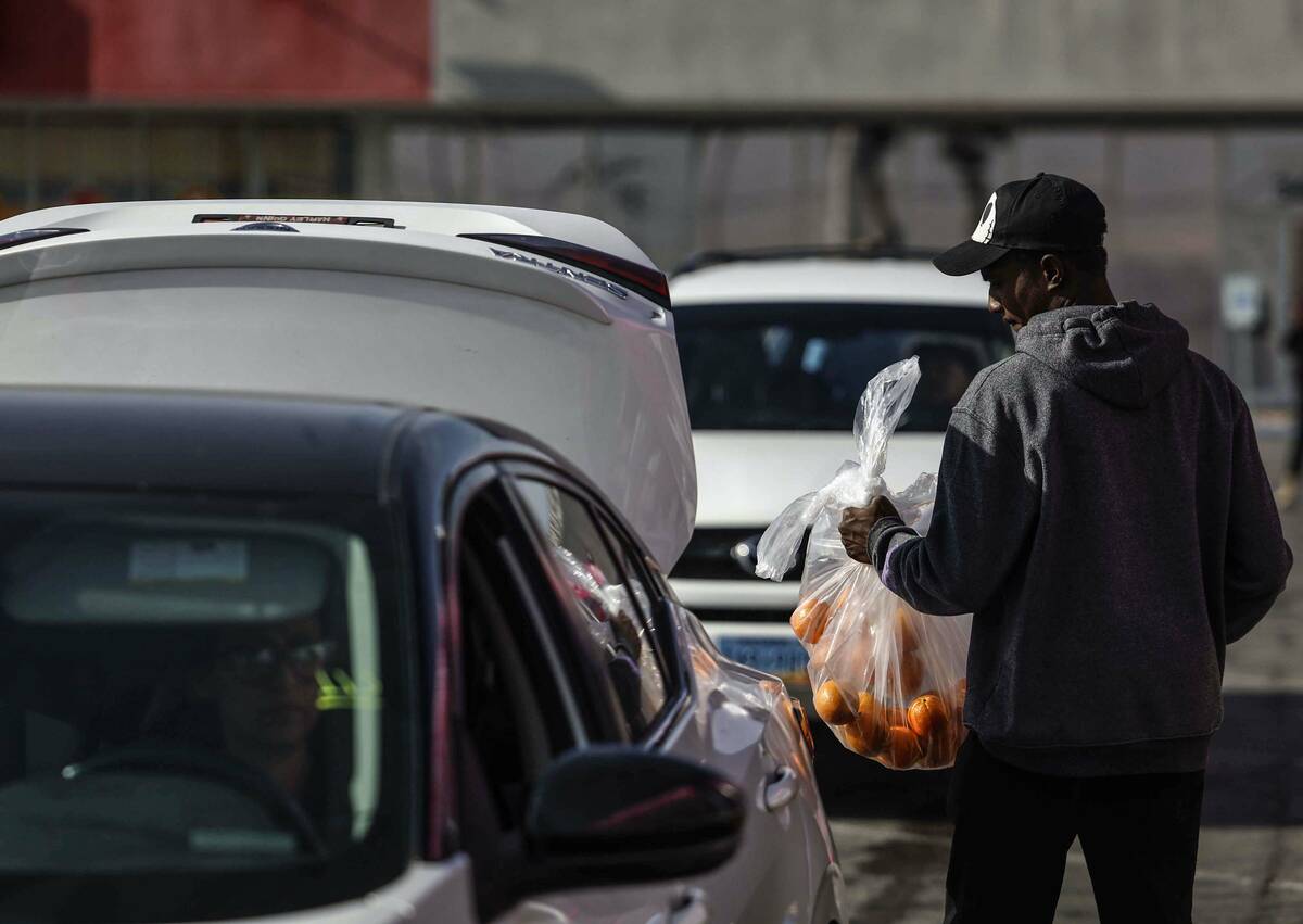 Volunteers bag and hand out food at The Just One Project Thursday, Dec. 18, 2025 in Las Vegas. ...