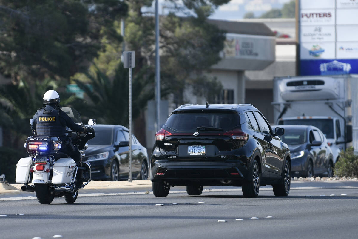 A police officer pulls over a vehicle after it failed to yield to a pedestrian in a crosswalk a ...