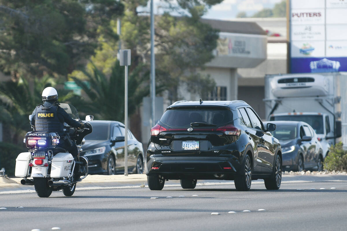 A police officer pulls over a vehicle after it failed to yield to a pedestrian in a crosswalk a ...
